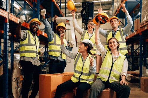 a group of people in safety vests attending workplace safety meeting about material handling safety.